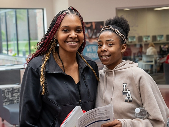 Two students in the College Hall Atrium