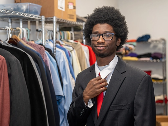 student in career closet wearing suit and tie