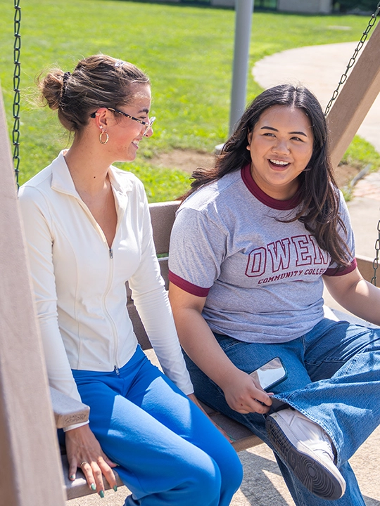 two students on bench swing