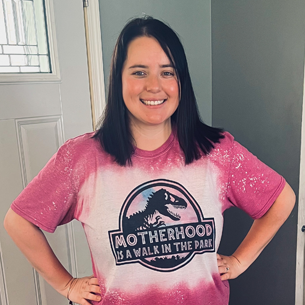 photo of allison with hands on hips smiling wearing graphic T shirt