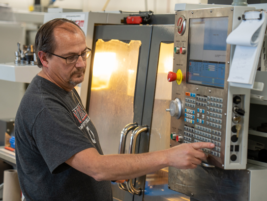 Man standing next to a machine using it