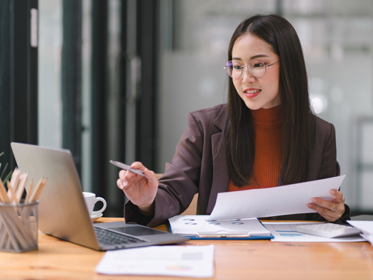 Corporate woman sitting at a desk working on a laptop