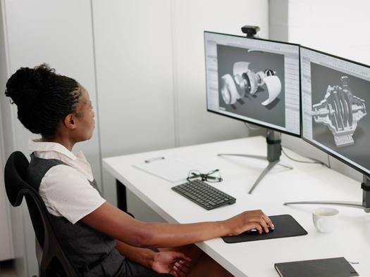 Female working at a desktop computer creating 3d models