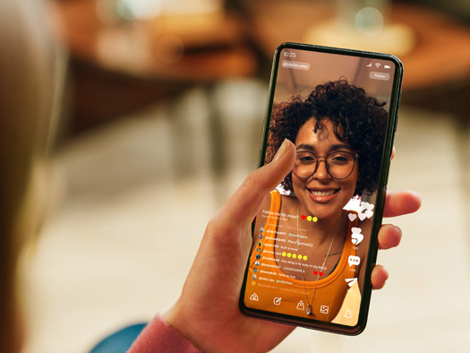 photograph of a hand holding mobile phone on a video call
