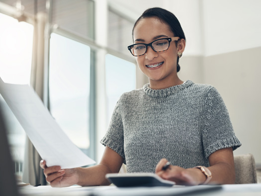 woman at desk using calculator