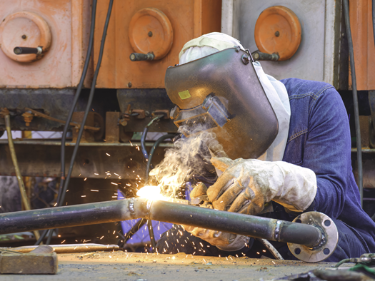 Person welding a pipe