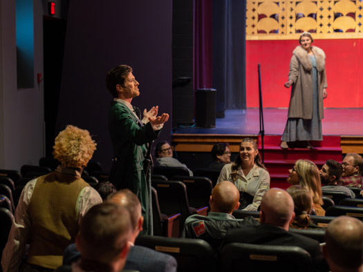 The director of a theater show standing in front of the stage