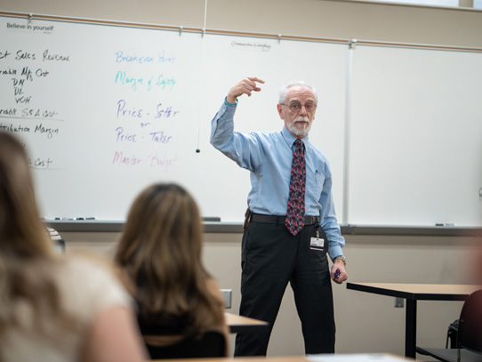 College instructor standing in front of the class giving a lecture