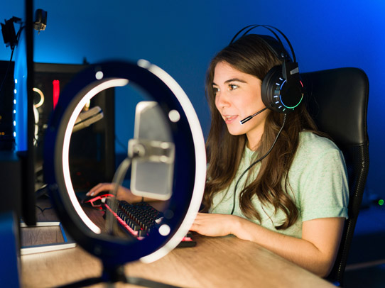 photograph of student recording self at desk lit by ring light