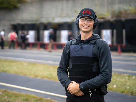 Young law enforcement student wearing ear protection at shooting range