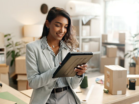 woman in professional clothing looking at tablet smiling