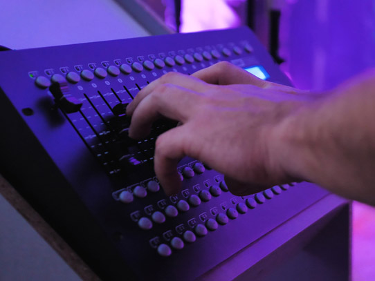 Man using a device to manage the sound levels in a theatre