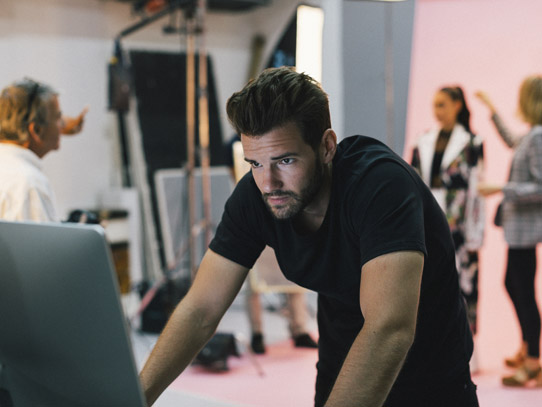 Man standing while working on a computer in a studio